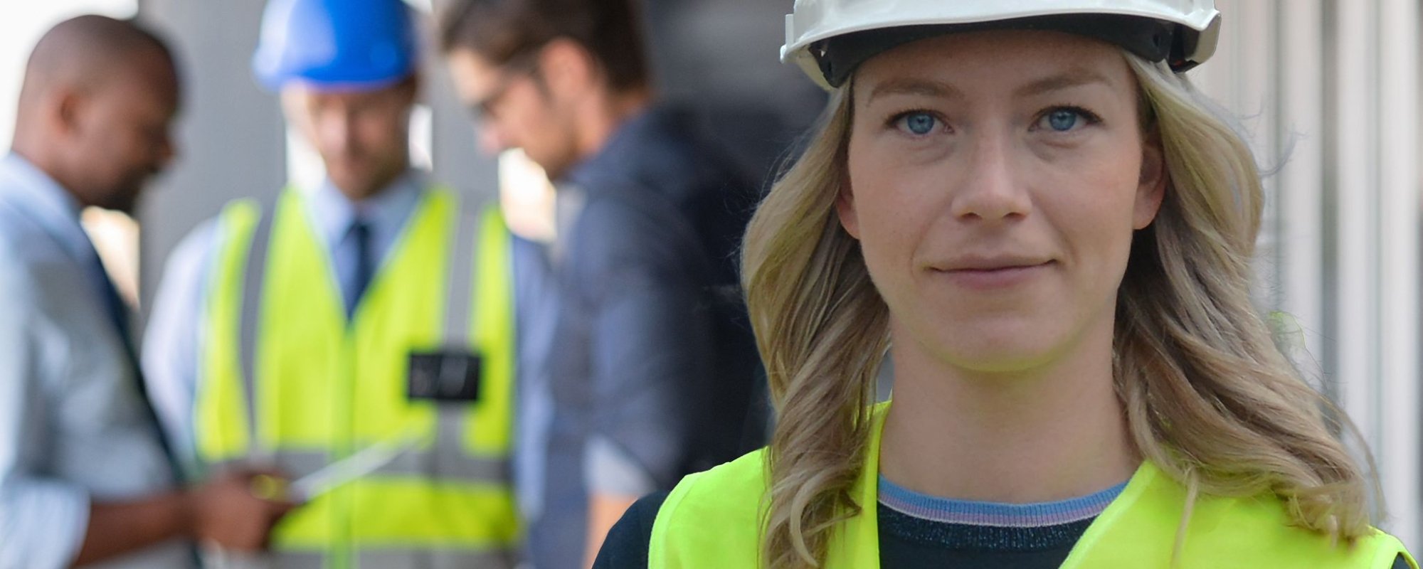 Anna van der Wal op de bouwlocatie met helm op en geel hesje