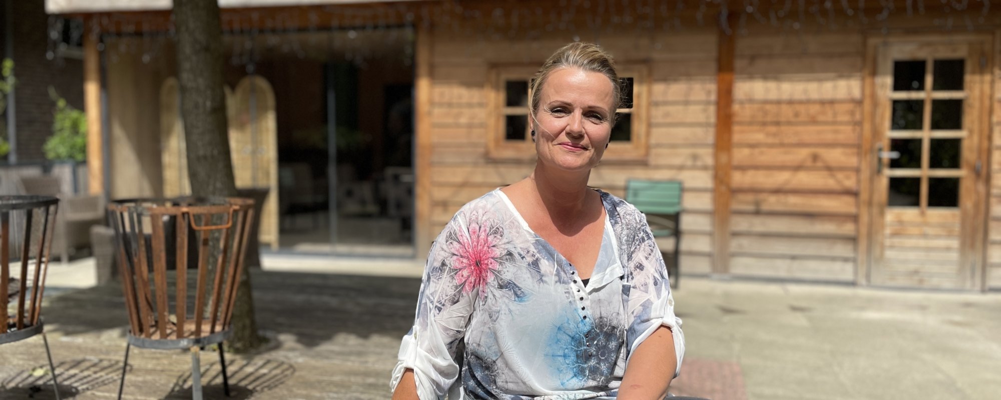 Dame zittend op een bankje in de tuin