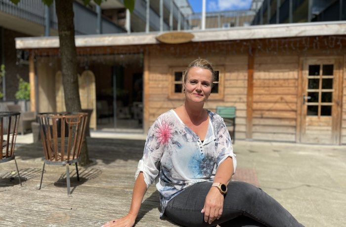 Dame zittend op een bankje in de tuin